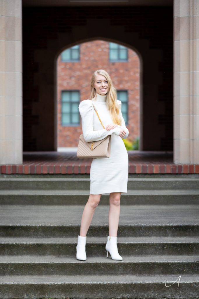 white sweater dress with puff shoulders, styled with saint laurent large envelope in beige with white booties
